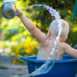 child lifting water dipper