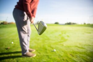 A golfer readies for a swing on a sunny course, showcasing the focus of the sport.
