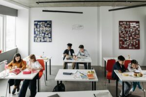 Students enjoy a light-hearted break in a modern classroom setting, fostering diversity and interaction.